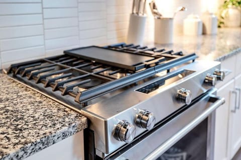 Kitchen with island stocked with pots, pans, and utensils
