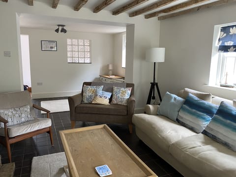 Spacious living room with plenty of seating, a log burner and smart TV.