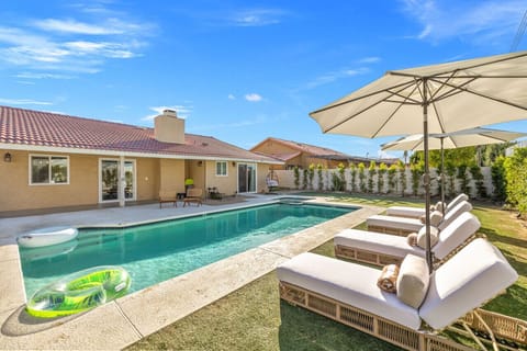 Sunlit pool w/ comfy loungers and umbrellas, ideal for lazy afternoons & refreshing dips.