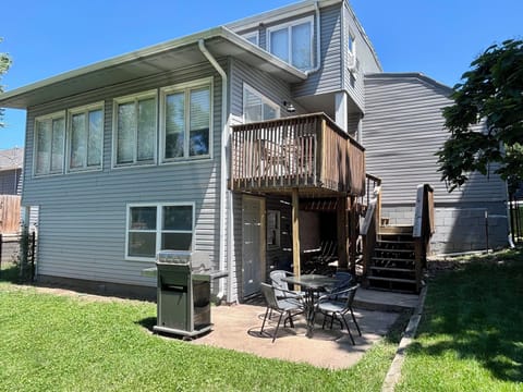 Exterior of the back side of the home- fenced in w/ outdoor seating & grill