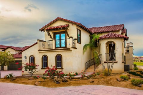 The front view of this condo in El Dorado Ranch features desert landscaping and a shaded front patio, with nearby access to community pools and the beach