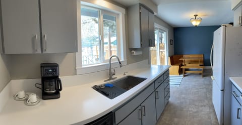 Deep sink, coffee maker and a fully stoked kitchen