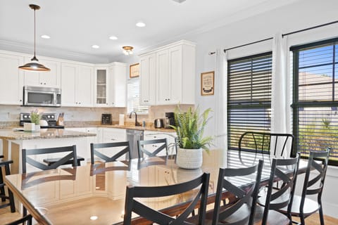 Large dining table with enough seating for 8 people. The dining area is located between the open kitchen and living room areas.