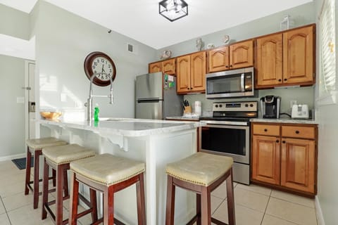 Kitchen - The compact, yet ample kitchen provides stainless appliances, fully stocked cabinetry, and seating for 4 at the eat-in bar.