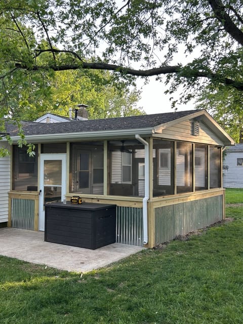 Brand new screened in porch with dining table and grill on concrete patio.