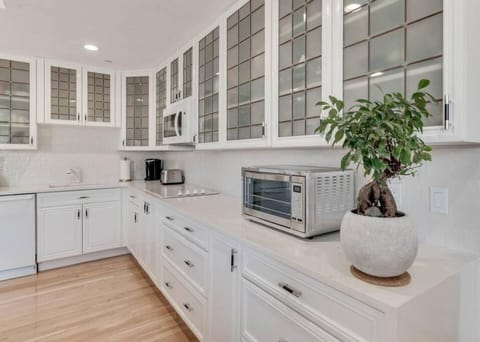 Fully stocked kitchenette with glasses, microwave, Refrigerator, Keurig coffee maker, glasses, plates, and cutlery