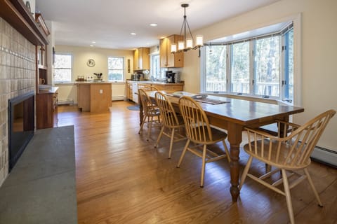 Dining room looking into kitchen past the dining table and fire place