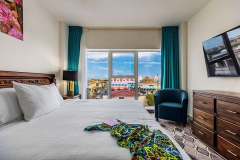 Sink into crisp white linens and wake to vibrant rooftops framed by teal curtains—your peaceful retreat opens to a colorful neighborhood just beyond your window.