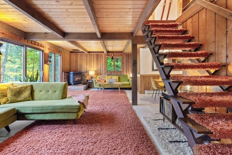 Living room with shag stairs and wood beams—pure retro charm.
