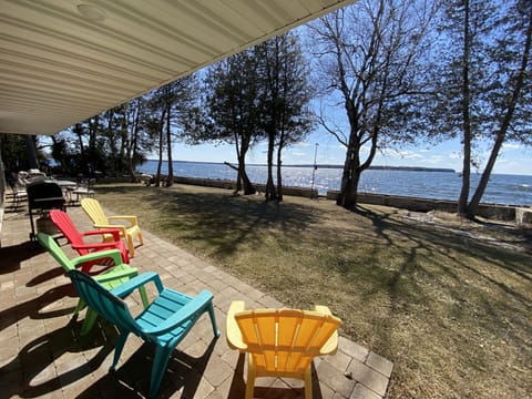 Views from the massive covered porch overlooking yard, fire pit, and waterfront