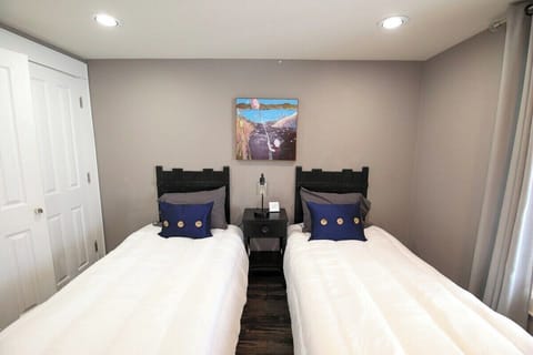Bedroom with (2) single beds and nightstand with charging station