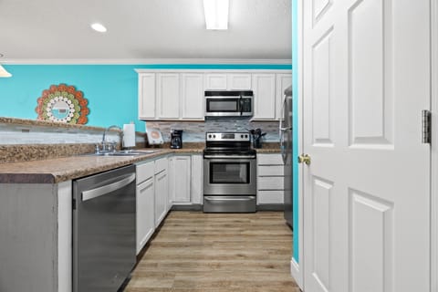 Kitchen bar with newer appliances and washer and dryer for your convenience. Provided for your use is an oven, dishwasher, refrigerator, coffee maker, toaster and blender.