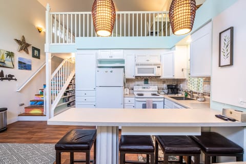 The kitchen area has a counter with 4 barstools for casual seating.