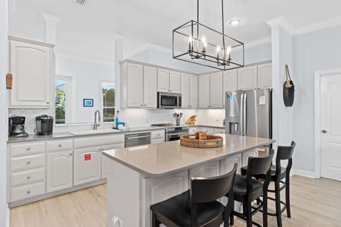 Your bright, modern kitchen offers everything you need with sleek white cabinets, stainless appliances, and a perfect island for morning coffee or casual meals.