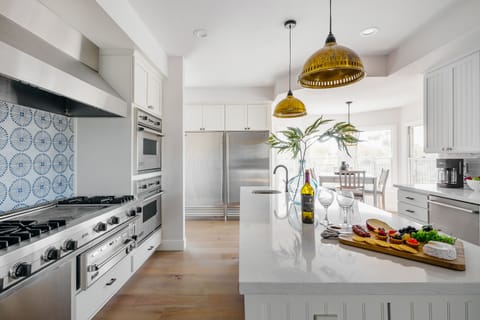 Bright fully equipped kitchen with stainless steel appliances, dual ovens, dual sinks, XL fridge, large island and breakfast table with incredible views of Camelback.