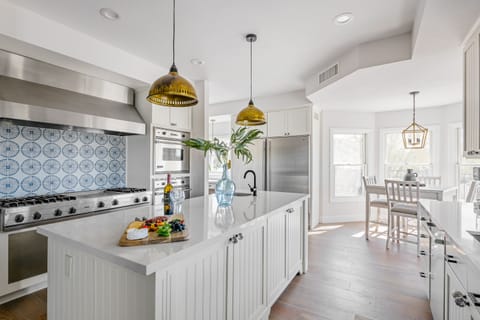 Bright fully equipped kitchen with stainless steel appliances, dual ovens, dual sinks, XL fridge, large island and breakfast table with incredible views of Camelback.