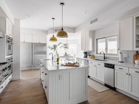 Bright fully equipped kitchen with stainless steel appliances, dual ovens, dual sinks, XL fridge, large island and breakfast table with incredible views of Camelback.