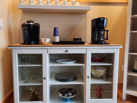 Serving bowls, dessert cups and martini glasses are stored in the buffet.
