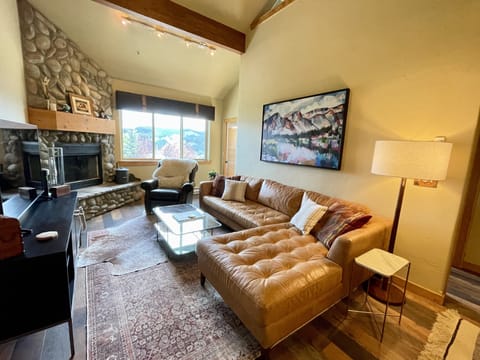 Wood burning fireplace and mountain views in the living room. Art by S. Dunn. 