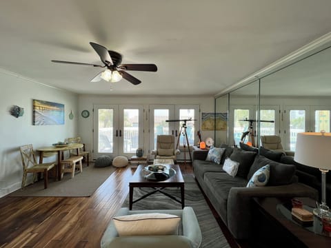 Relax in your spacious living room with cozy seating, ceiling fan, and bright windows overlooking the neighborhood.
