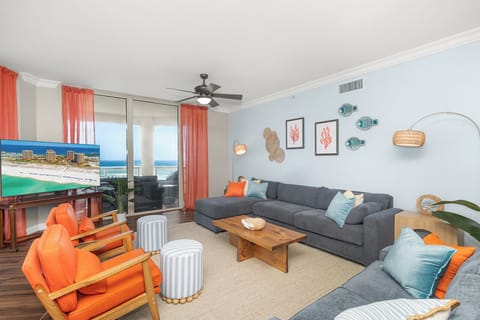 Relax in your coastal-themed living room where ocean views meet beach-inspired décor, complete with comfy seating and vibrant coral accents.