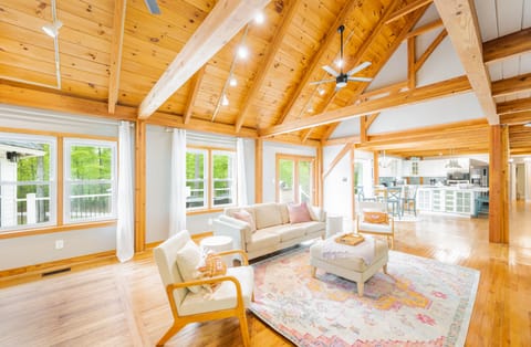 The main level living boho living room with high ceilings and exposed beams