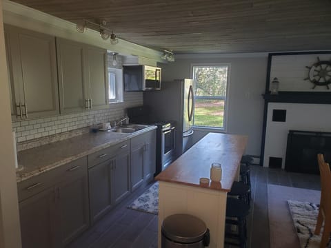 Kitchen with island and chairs. Stainless appliances