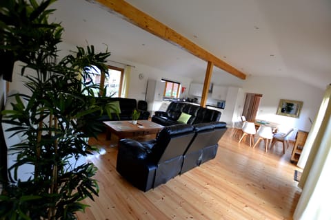 Open plan living area with cumfy reclining  seating & 65" smart TV.