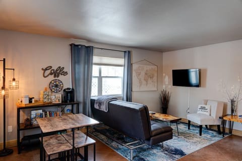 Living room with smart TV. Couch folds down into bed, extra linens and blanket are located in bedroom closet. Seating area behind couch is arranged differently now-- see updated pictures)