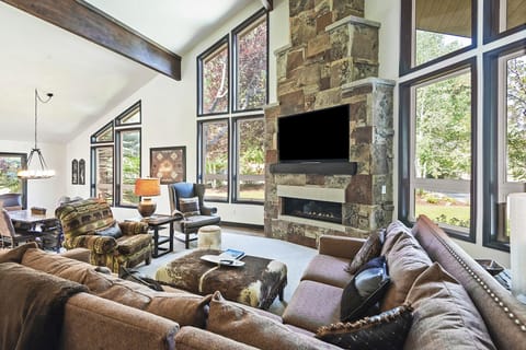 Open concept seating area with cable tv, fireplace, and floor to ceiling windows