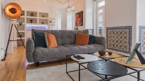 Unwind in this vibrant living area, where a comfortable sofa with colorful cushions invites relaxation after a day of sightseeing, surrounded by unique local tile artwork and modern design touches that create an eclectic ambiance. Natural light streams in