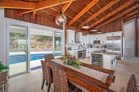 Enjoy pool views while dining together in this seamless kitchen and dining area.