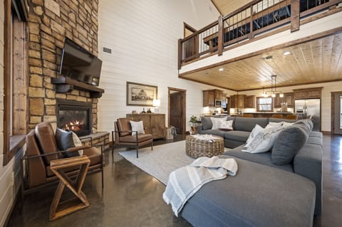 An oversized sectional placed around the floor to ceiling fireplace.
