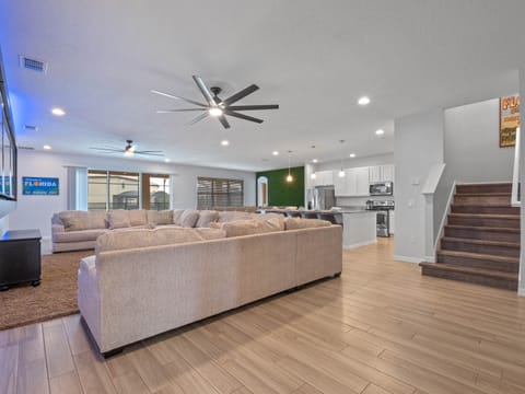 - Bright open concept with oversized sectional and modern design  
- Living area flows into dining and kitchen for easy gatherings  
- Orlando family vacation home with space for group relaxation