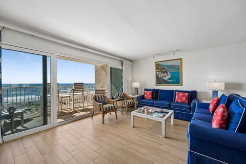 Your oceanfront living room invites you to unwind with vibrant coastal décor and floor-to-ceiling windows that frame endless sea views from your private balcony.