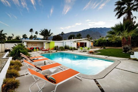 Desert Oasis with Stunning Mountain Views! 🌴☀️ Dive into relaxation in this sparkling pool, soak up the sun on vibrant loungers, or unwind in the chic outdoor lounge. With breathtaking mountain views and lush landscaping, this mid-century retreat is the u