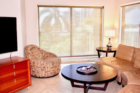 Living room with a TV, balcony access and sofa (not a sofa bed). Linens and blanke for the sofa are provided.