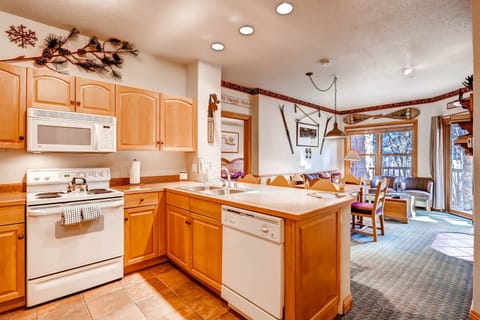 Enjoy the cozy mountain-style kitchen featuring warm wooden cabinetry and modern appliances, perfect for whipping up home-cooked meals.