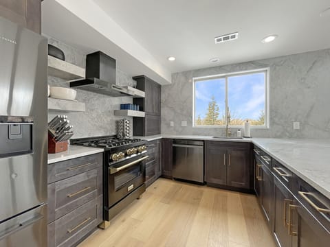 "A chef’s dream: this fully equipped kitchen features high-end appliances, custom stone countertops, and stunning cabinetry designed for effortless entertaining.