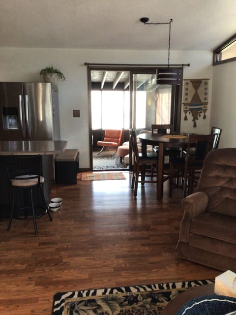 Photo from living room toward kitchen and dining area and out to screened porch.