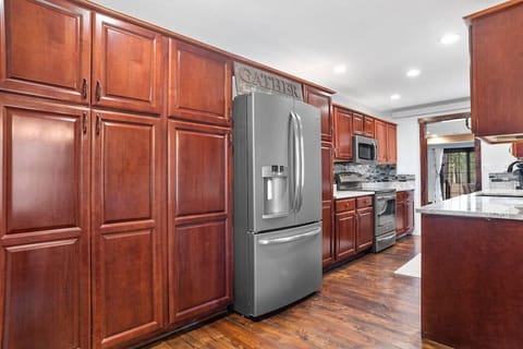 Spacious kitchen showcases abundant cabinet storage and a gleaming stainless-steel refrigerator.