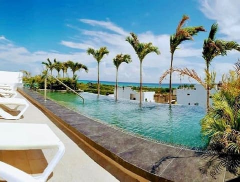 Disfruta de la piscina en el techo del condominio, con vistas al mar.
