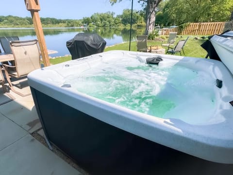 Relax in the private hot tub with bubbling waters - Take in serene lakefront views while you unwind - Perfect outdoor spot for evening gatherings by the grill