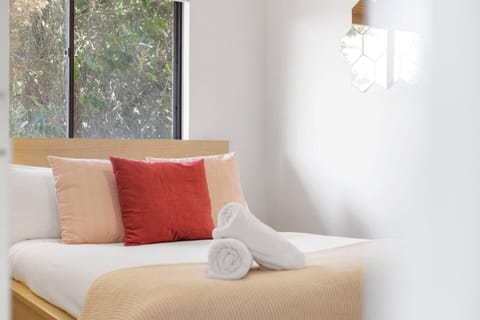 Cozy, sunlit retreat with plush bedding and peaceful views your perfect escape awaits.