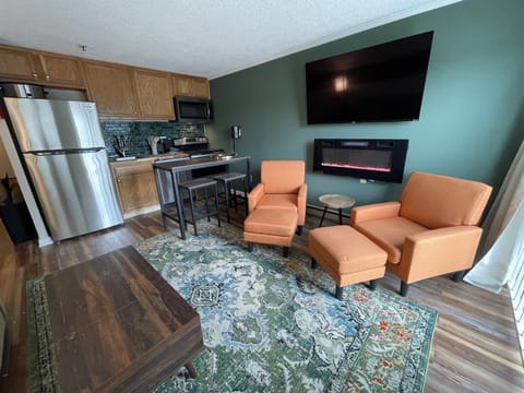 Living room with Fireplace, Smart TV, comfortable chairs, brad new sleeper sofa, coffee table, dining table. 