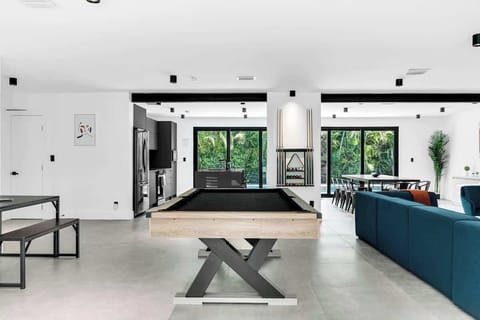 Spacious game‑ready Airbnb with a sleek pool table, open‑concept kitchen, and bright lounge area. Perfect vacation rental for families and groups to relax, entertain, and enjoy a fun getaway together.