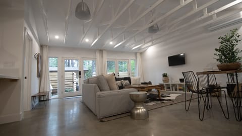 Large great room with vaulted ceiling, polished concrete floors.