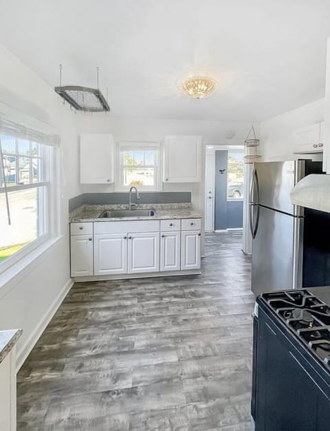 Bright & light kitchenette w/ updated kitchen sink & cupboards; newer floor