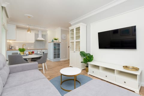 Living room with a gray sofa, wall-mounted TV, and modern decor.
