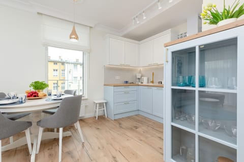 Kitchen with white cabinetry, shelves, and modern appliances.
